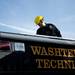 Participant of the rescue simulation, Kevin Dillen, checks for helmets on top of an emergency vehicle on Sunday. Daniel Brenner I AnnArbor.com